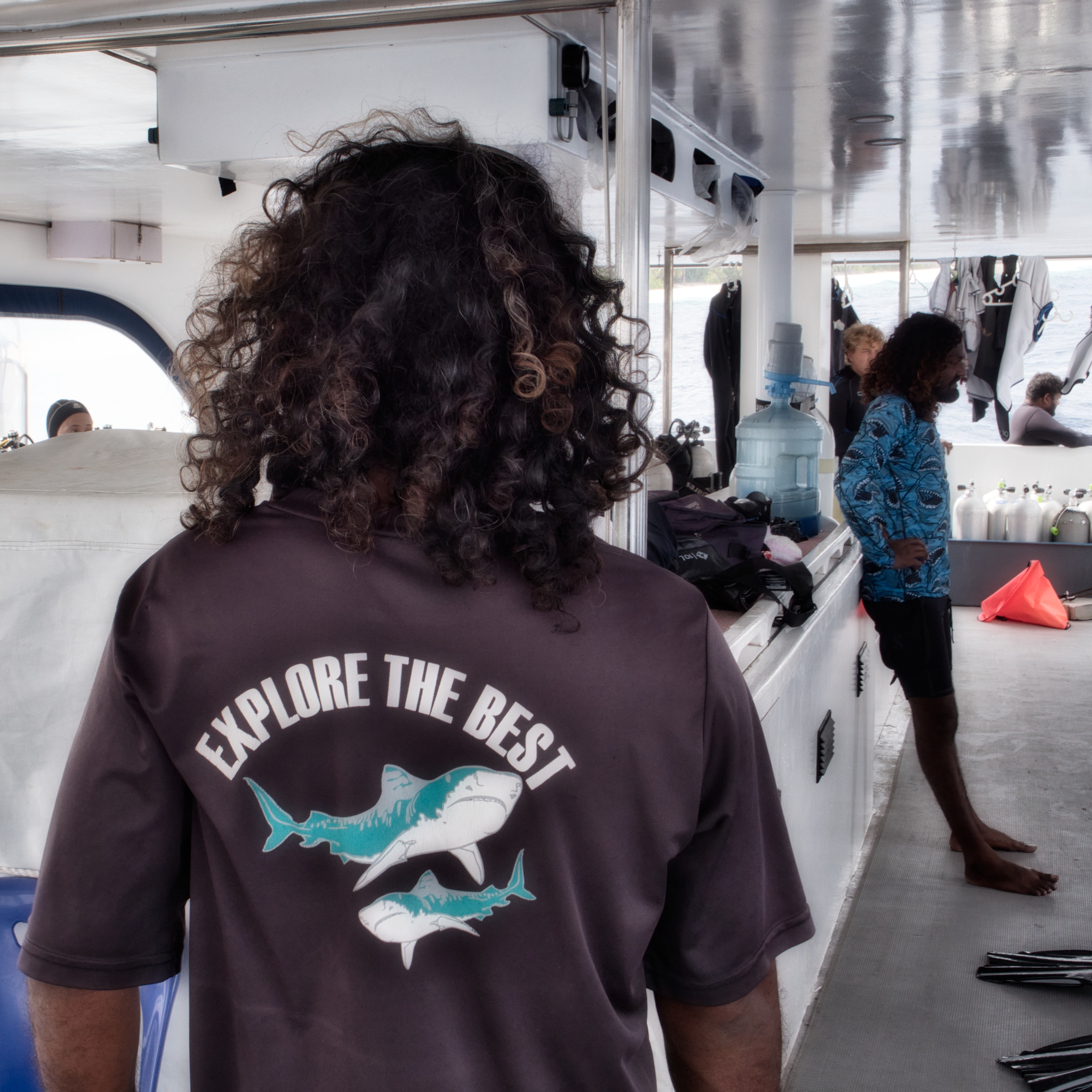 Diver on a boat in Fuvahmulah wearing an Explore the Best shark shirt before a scuba dive in the Maldives
