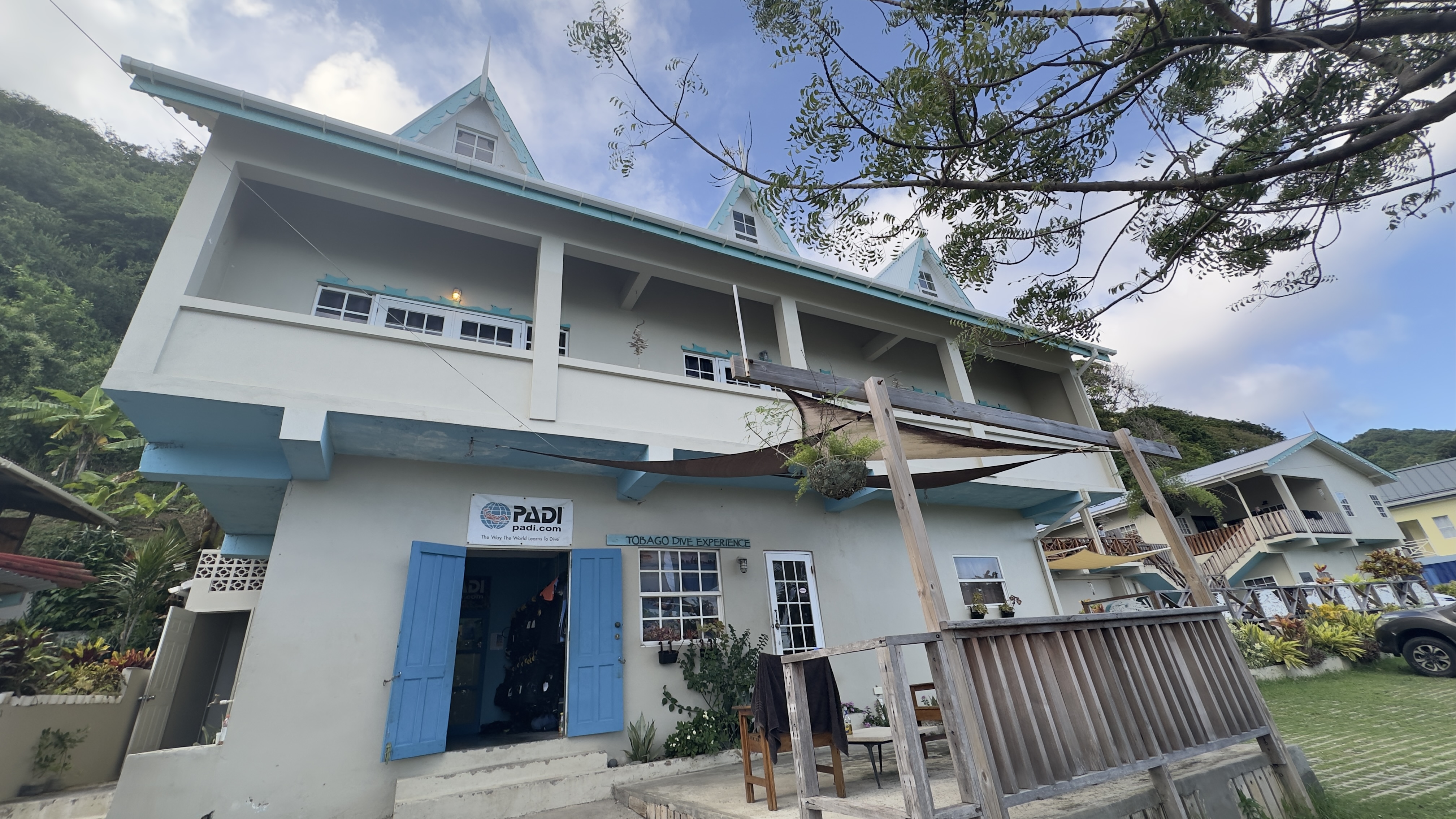 Exterior of Tobago Dive Experience dive shop in Speyside, Tobago with blue doors and PADI sign